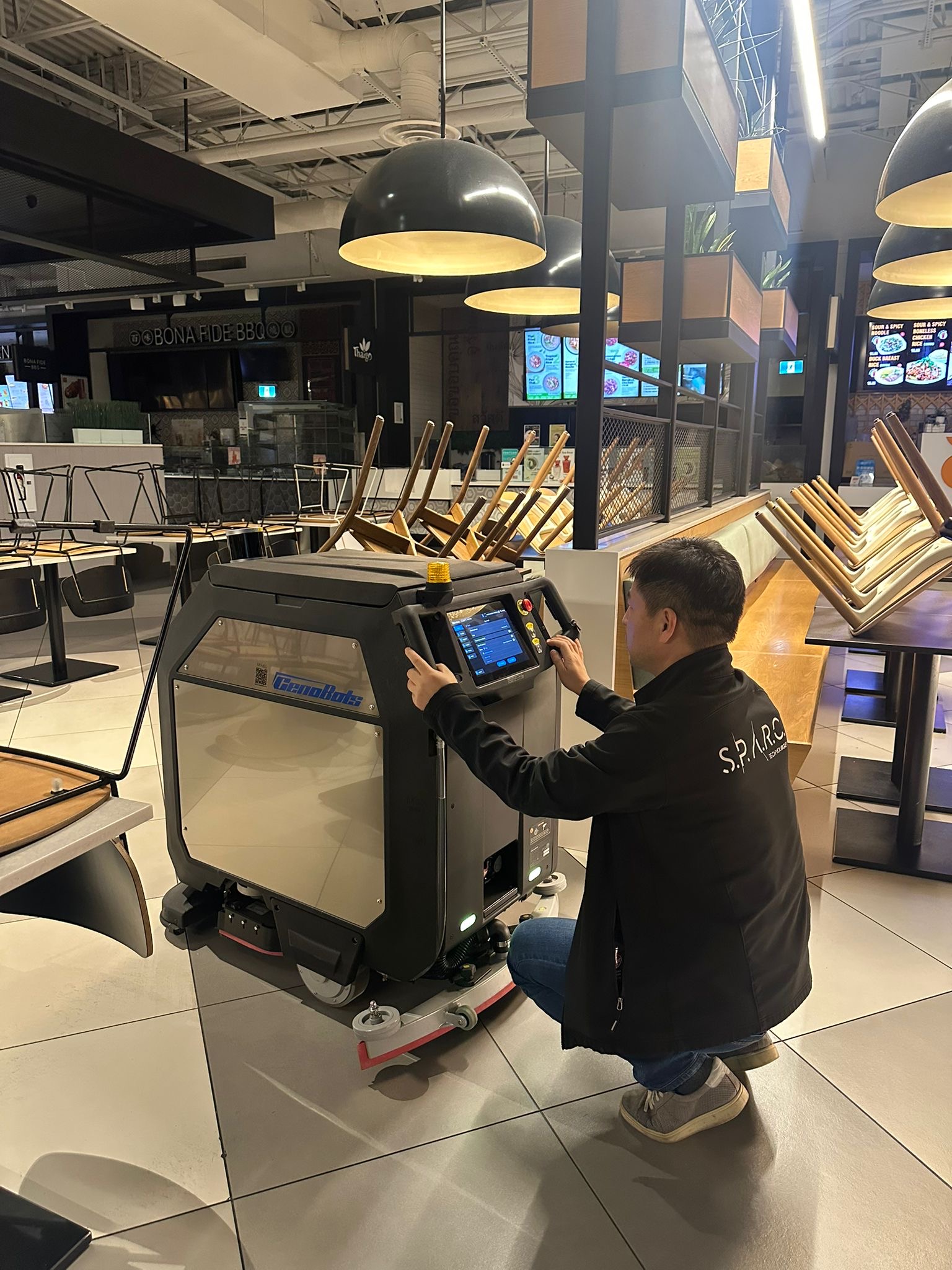 A SPARC technician servicing a cleaning robot on site