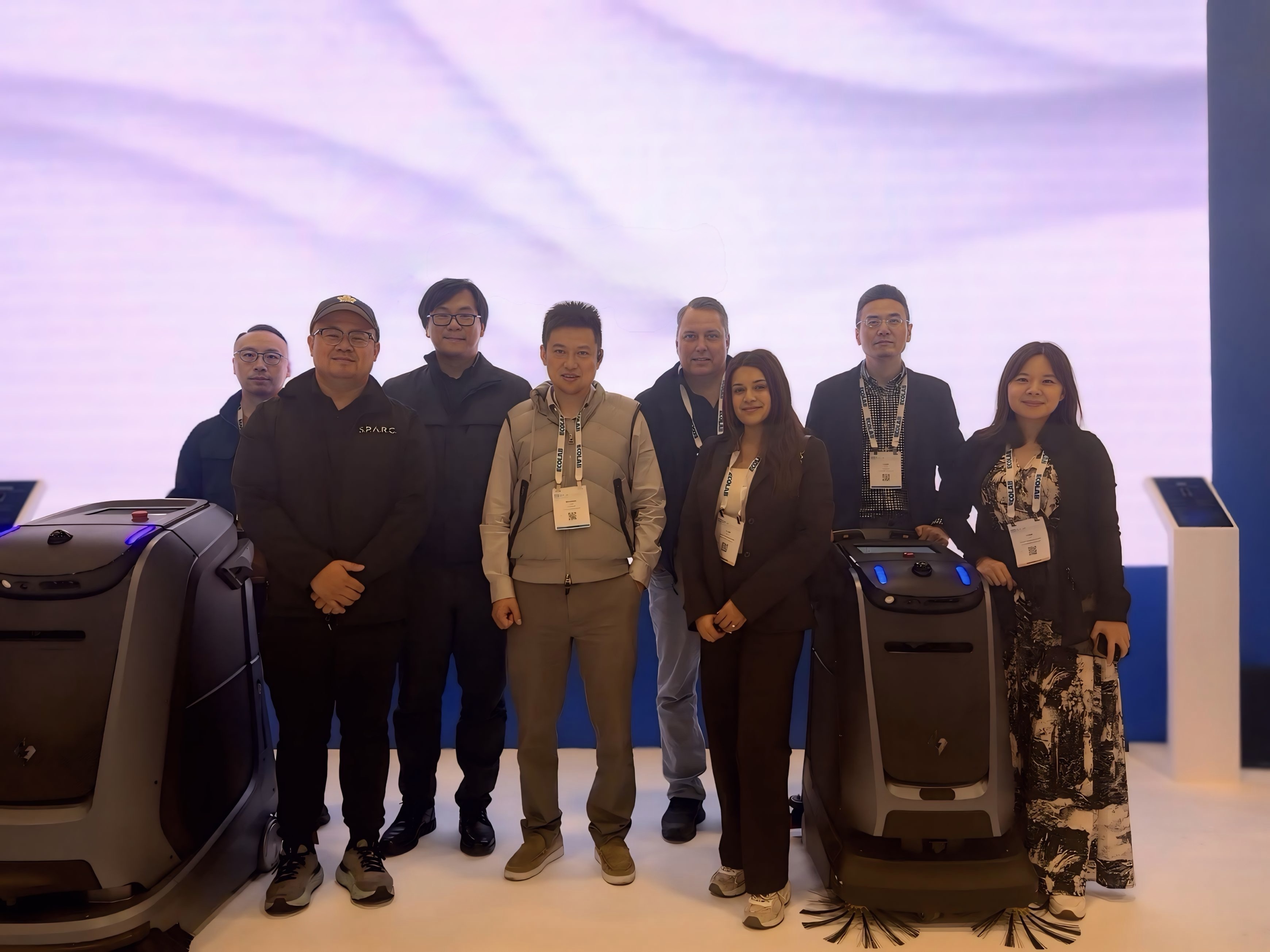 The SPARC team at the Gausium booth with cleaning robots